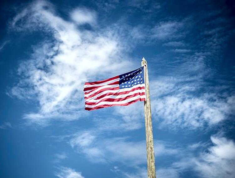 USA flag flying with blue sky background